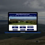Millom Without Parish Council website showing minutes, agenda and finances sections on a blue laptop against Lake District fell backdrop