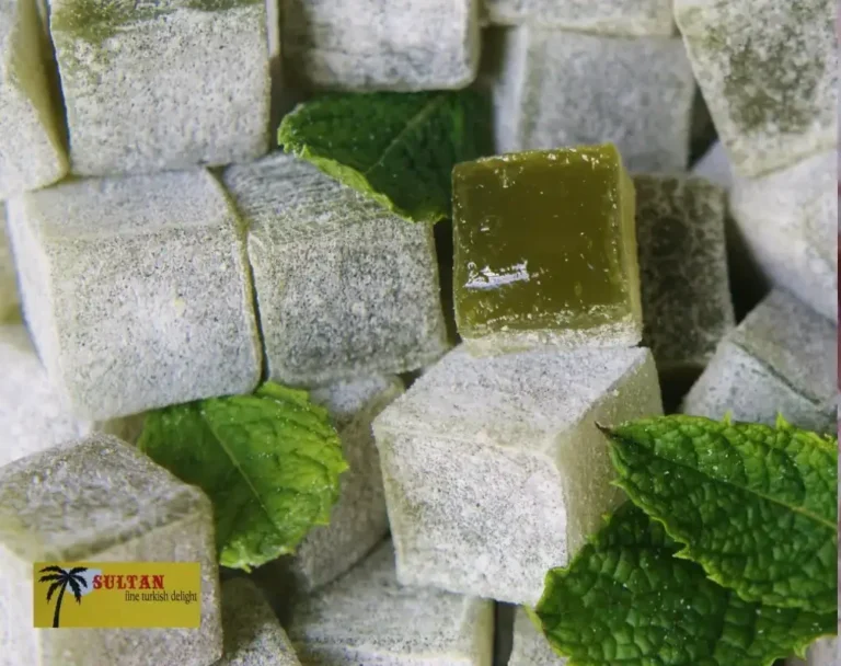 Close-up of Sultan Delights mint Turkish delight pieces dusted with icing sugar and fresh mint leaves